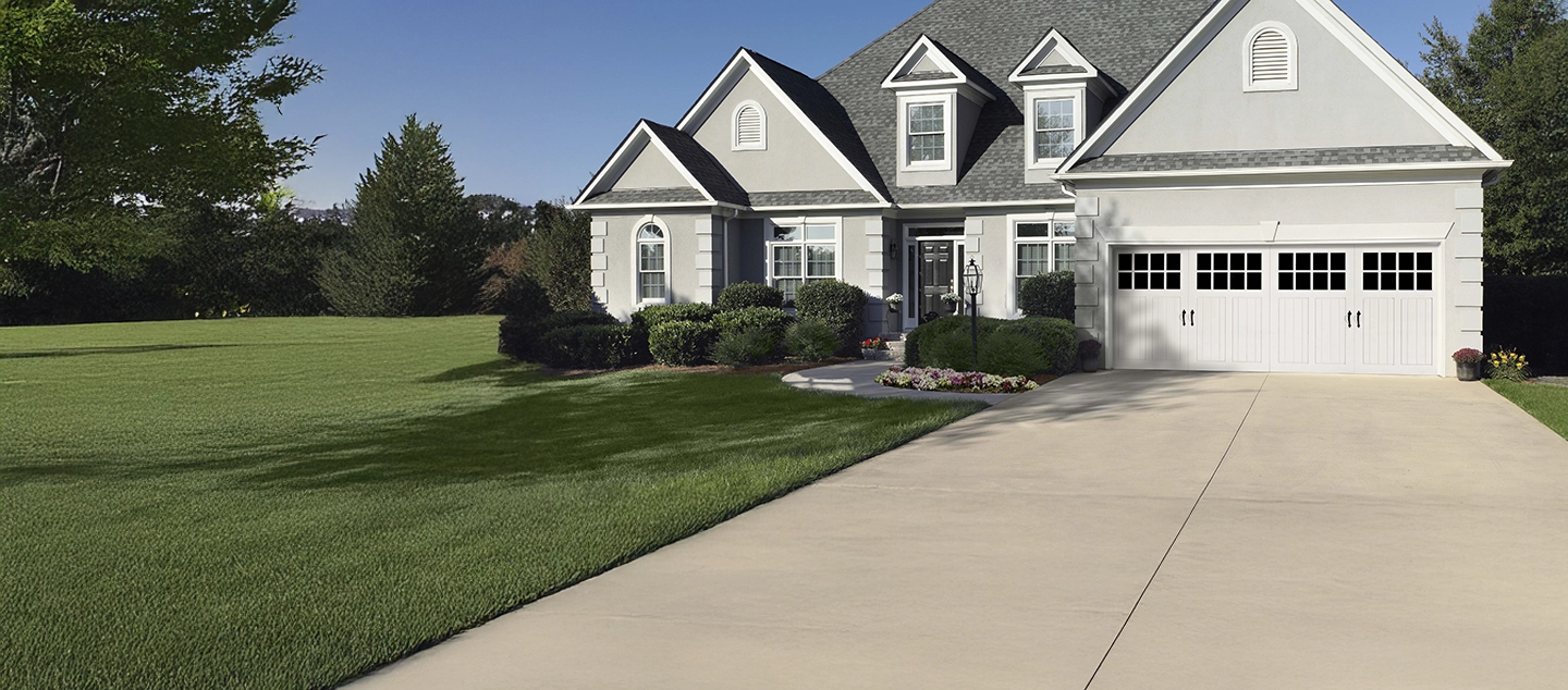 Stone house with triple wood door and a flower bed.