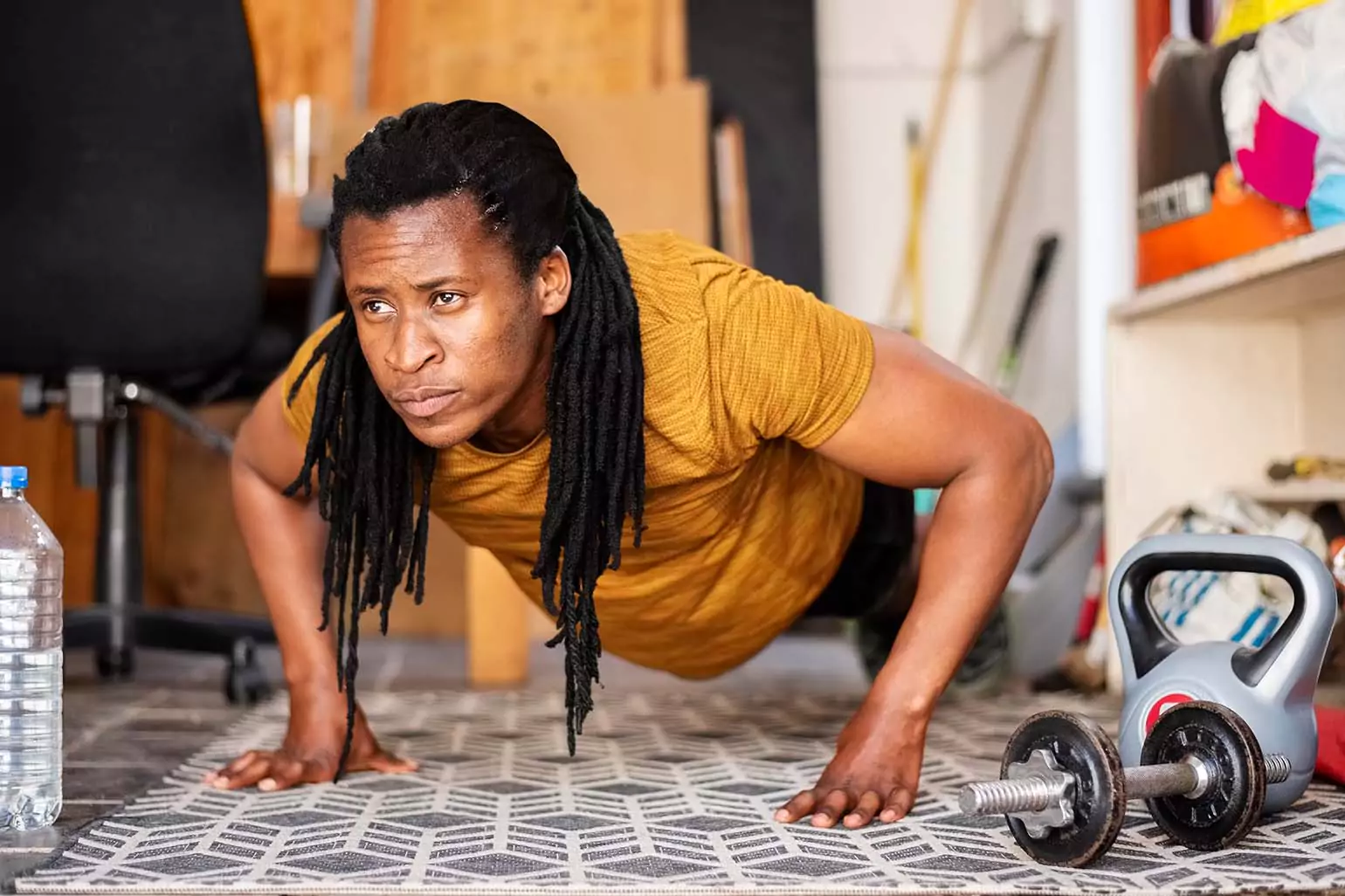 Person working out in their garage with only weights and a mat