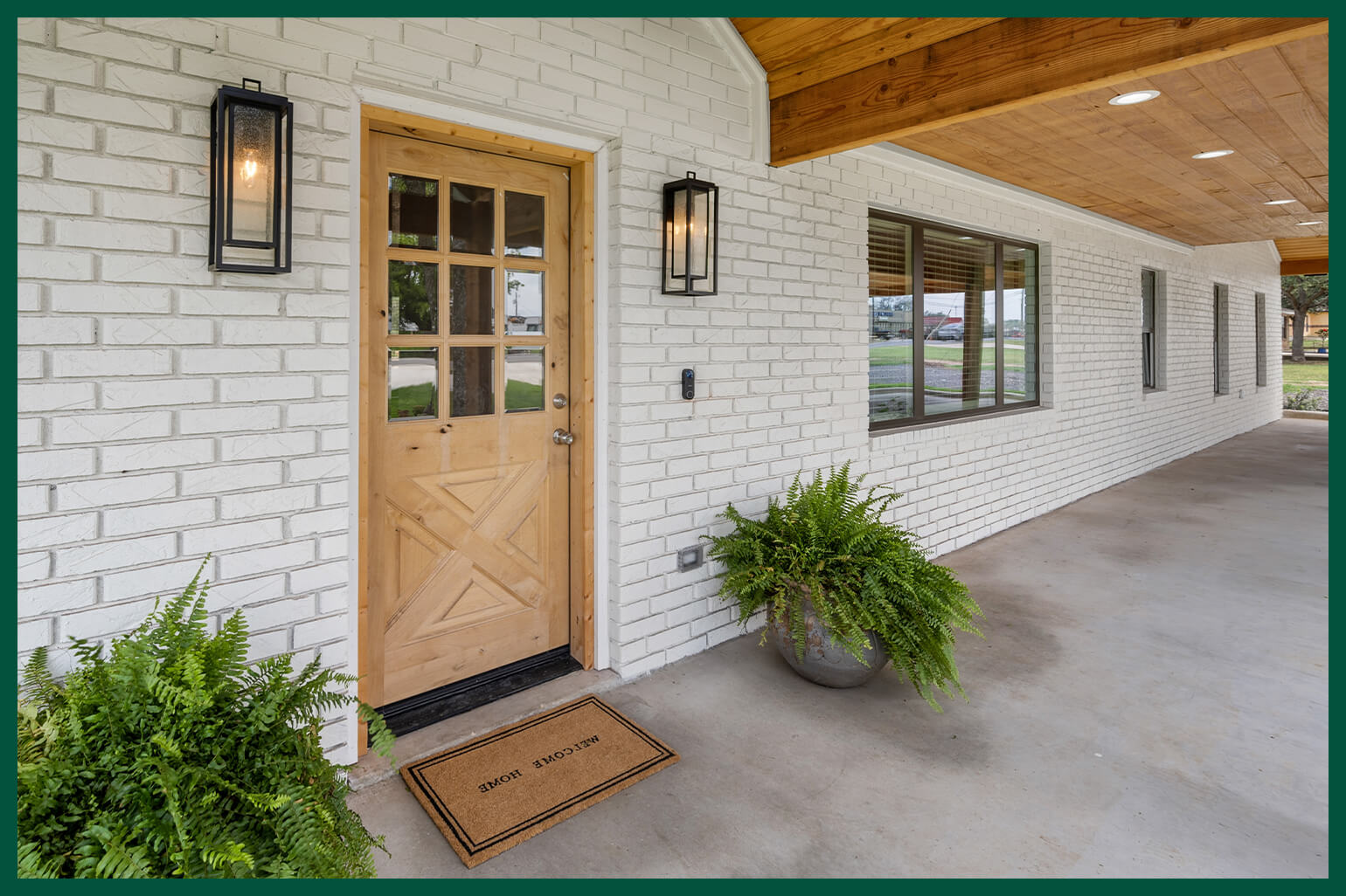 Large house with entryway accented by planters