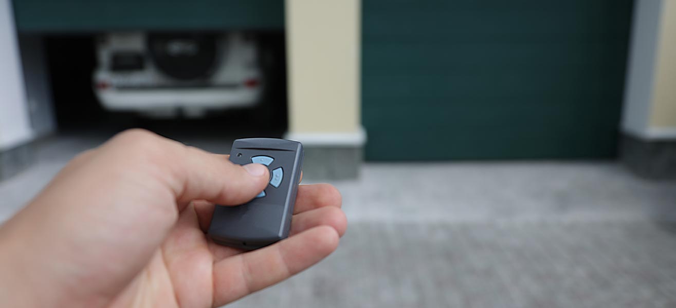 A person uses their garage door opener remote.