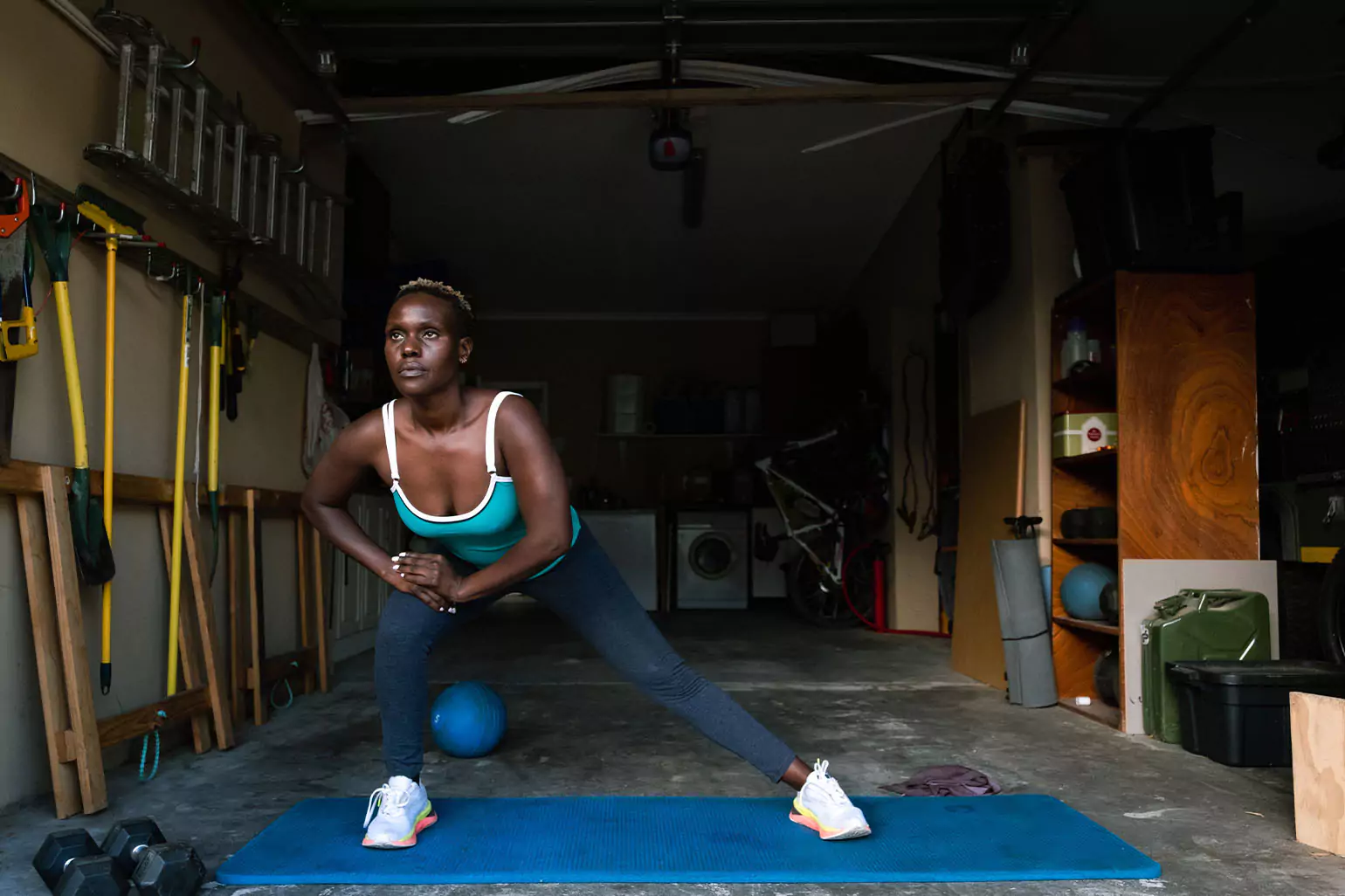 A person stretching in a small garage gym