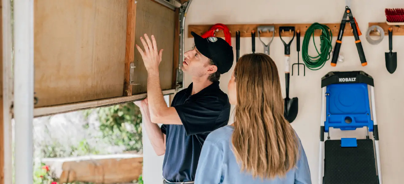 A Precision Garage Door Service professional helps a customer fix their noisy garage door.