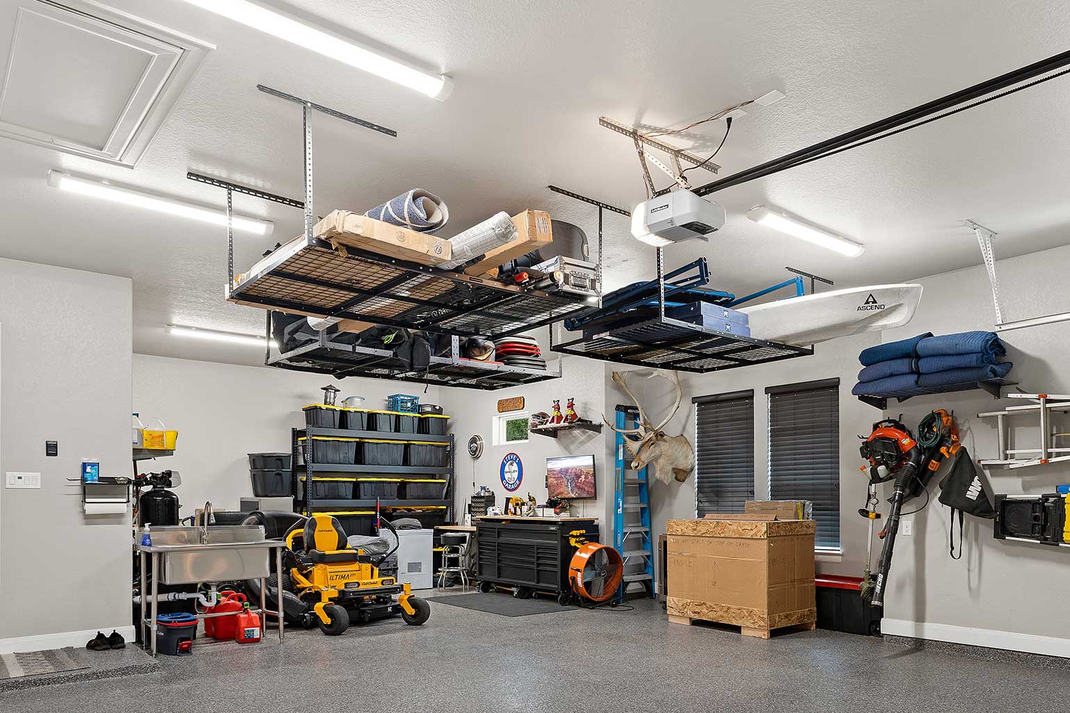 Overhead storage racks and bins in a garage.