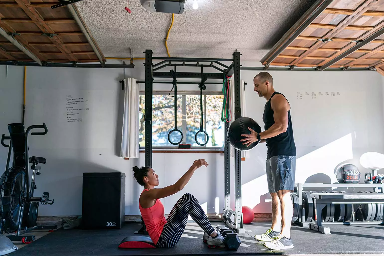 A couple working out together in a garage.