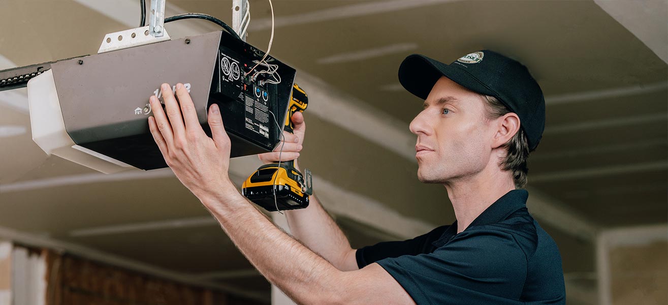 A Precision Garage Door Service professional installing a garage door opener.