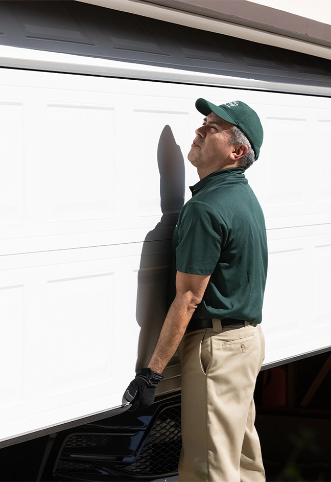 A PDS expert lifting a garage door.