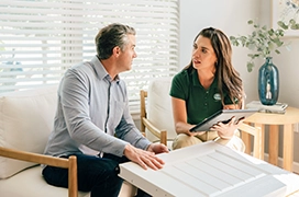 A PDS employee sitting in chairs and discussing garage door plans with a client.