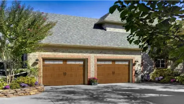 Brick house with double cedar garage doors.