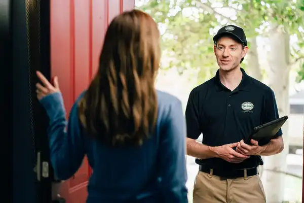 A Precision Garage Door service professional greeting a homeowner at the door.