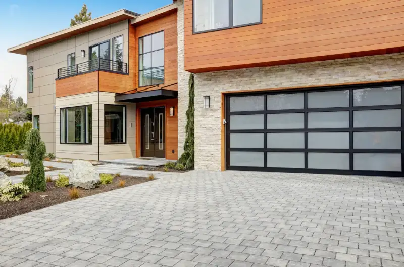 Modern house with stylish fixtures and full-view garage doors.