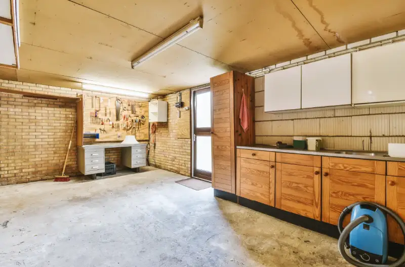 A brick and wood garage with a side door allowing natural light to fill the space.