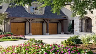 Luxury triple garage doors on stone house.