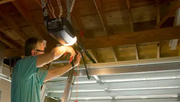 A man trying to fix a garage door.