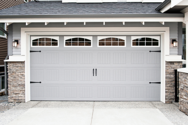 A modern grey garage door with four small windows at the top. | Precision Garage Door Service of Chattanooga