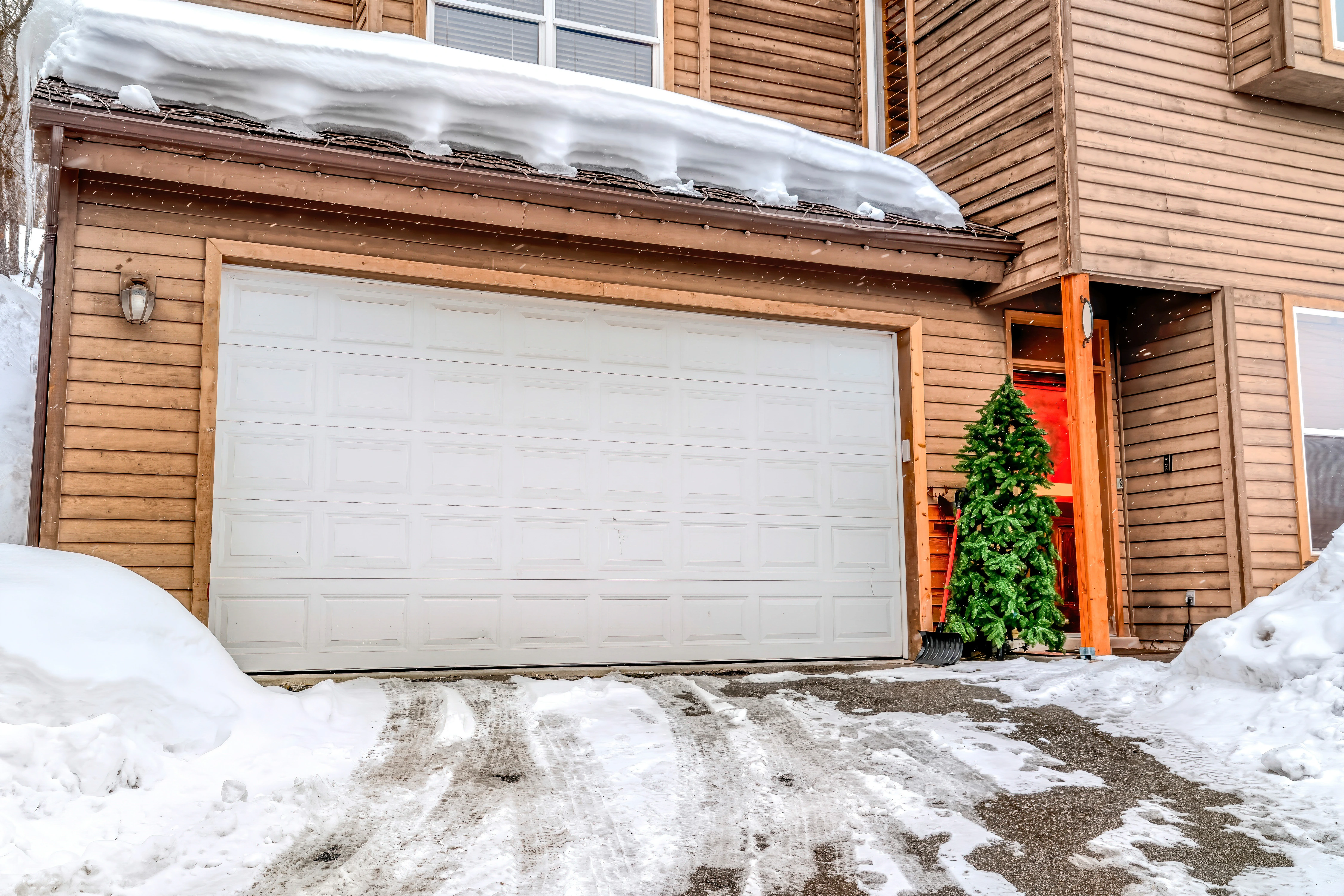 Snowy driveway in front of insulated garage door
