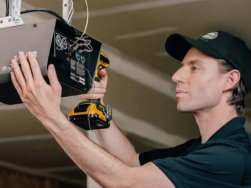 A Precision Garage Door Service professional installing a garage door opener.